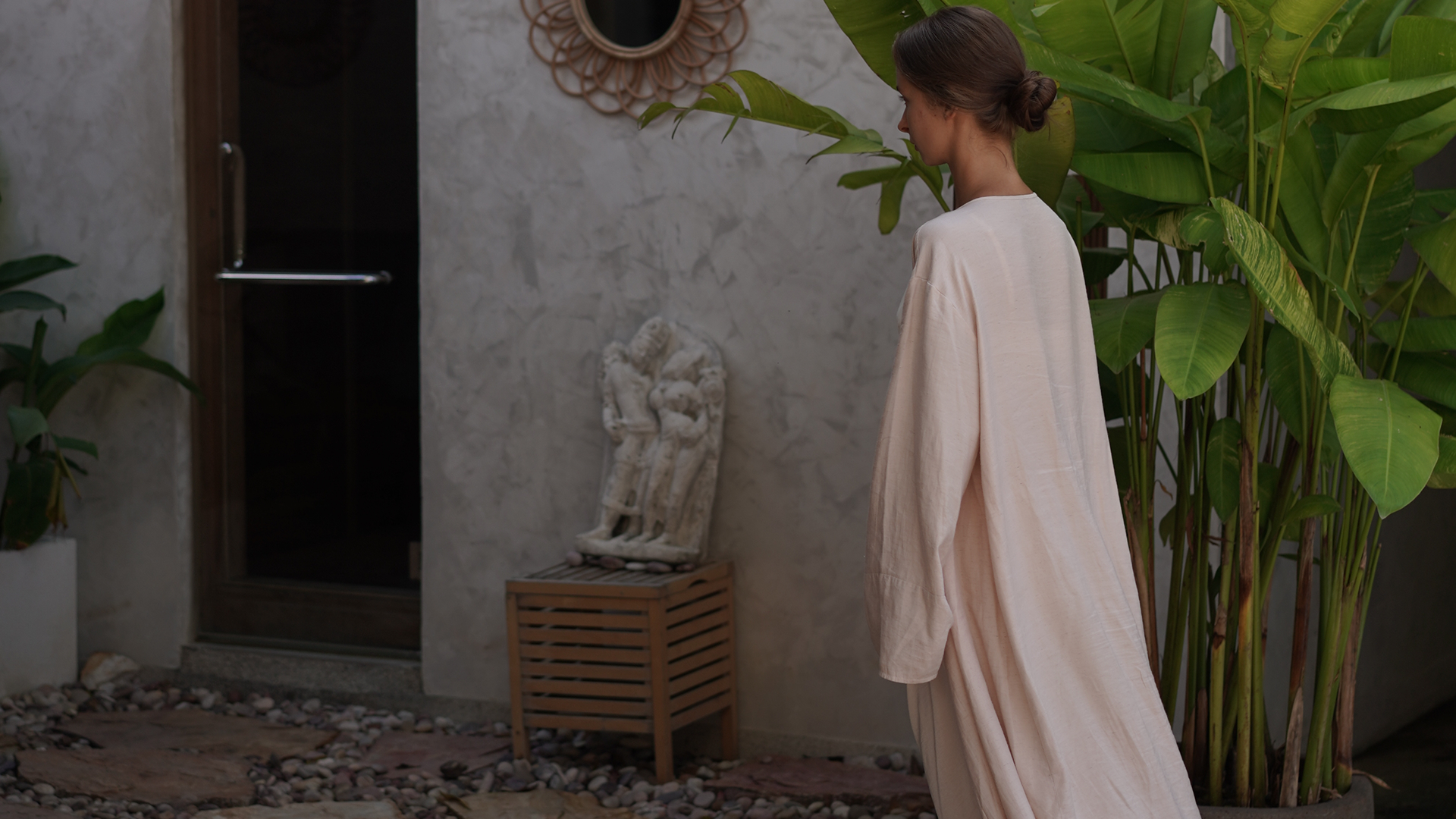 Guest in linen robe arriving at Maji Recovery Oasis garden